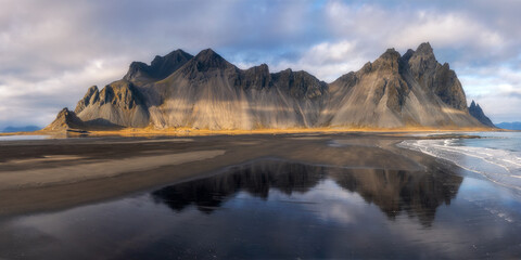 Aerial view on black sand beach and mountain range.