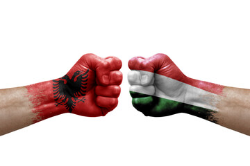 Two hands punch to each others on white background. Country flags painted fists, conflict crisis concept between albania and hungary