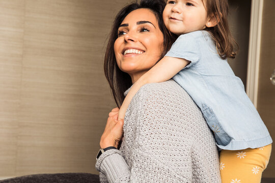 Little girl and her mom hugging in bed