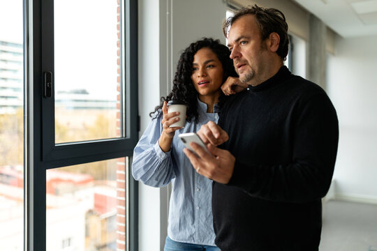 Partners checking phone in rental office