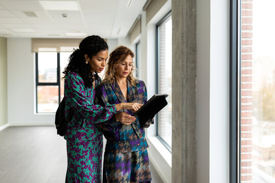 Women reading rental contract at empty flat