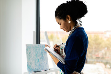 Artist drawing on notebook at studio