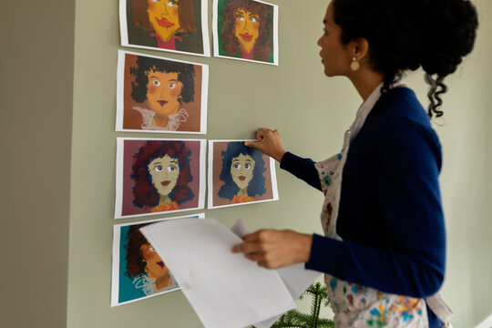 Woman decorating her studio walls with illustrations