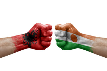 Two hands punch to each others on white background. Country flags painted fists, conflict crisis concept between albania and niger