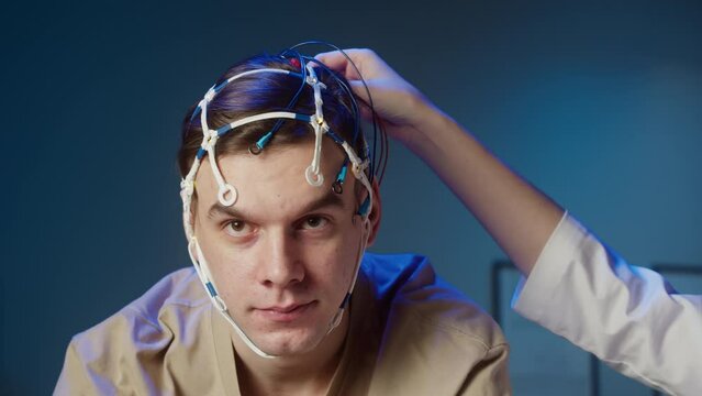 EEG topographer for examining brain, doctor making electrogram of scalp activity. Researching of brain work, man riding bicycle in electroencephalography headset. Rehabilitation after damage in sport.