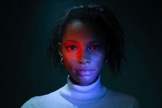 modern woman, female face in neon light in studio