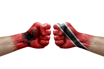 Two hands punch to each others on white background. Country flags painted fists, conflict crisis concept between albania and tobago