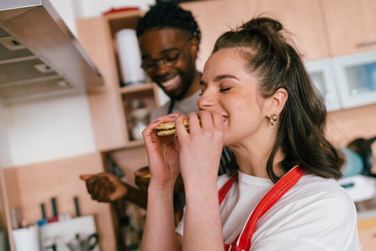 The woman eats homemade cookies.