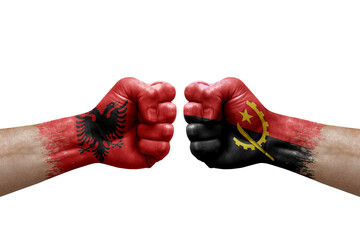 Two hands punch to each others on white background. Country flags painted fists, conflict crisis concept between albania and angola