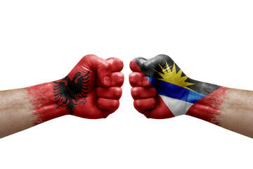 Two hands punch to each others on white background. Country flags painted fists, conflict crisis concept between albania and antigua barbuda