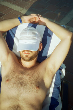 Boy hiding face under kepi and suntanning outdoor