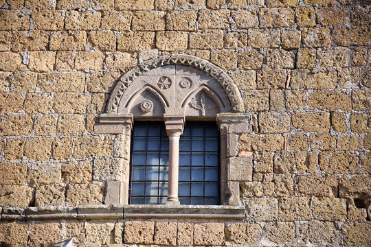 Mullioned window in a tufaceous stone wall, Tuscania, Tuscia, Lazio, Italy