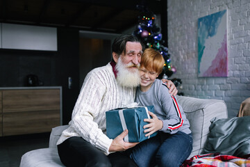 Little boy greeting his grandfather with Christmas