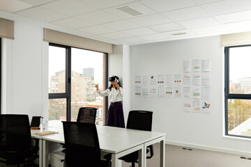 Business woman using virtual reality glasses in office