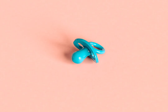 a blue pacifier on a pink background