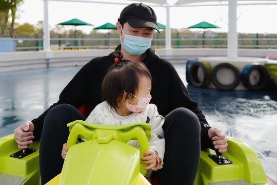 Baby and dad drive a bumper car together