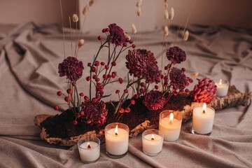 Floral composition and candles on plaid
