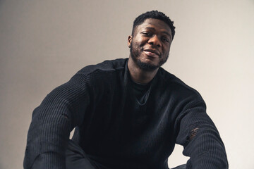 smiling black men sitting looking at the camera white background - portrait shot. High-quality photo