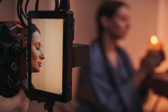 Camera shooting young woman with candle 
