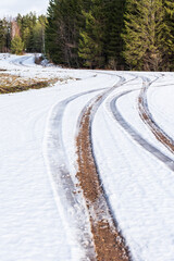 Fototapeta na wymiar Winding gravel forest road in winter day, Latvia.