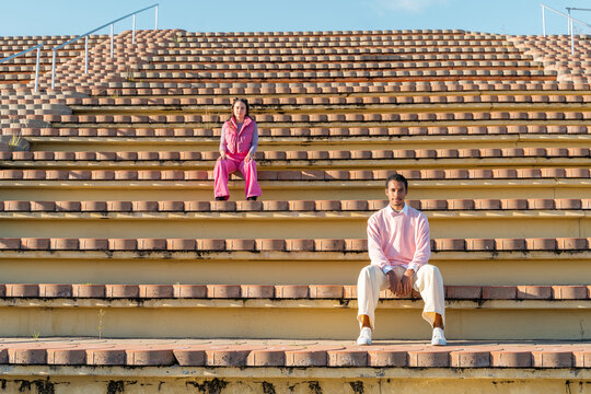 Dancer friends sitting on empty outdoor tier