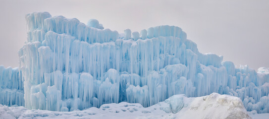 Panorama ice wall with dripping and freezing water making a beautiful winter formation out of giant icicles - obrazy, fototapety, plakaty