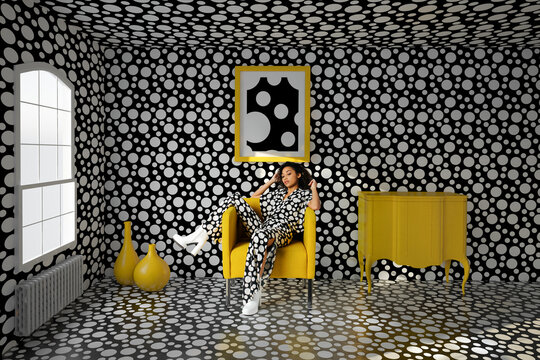 Portrait of a young woman lying on a yellow armchair
