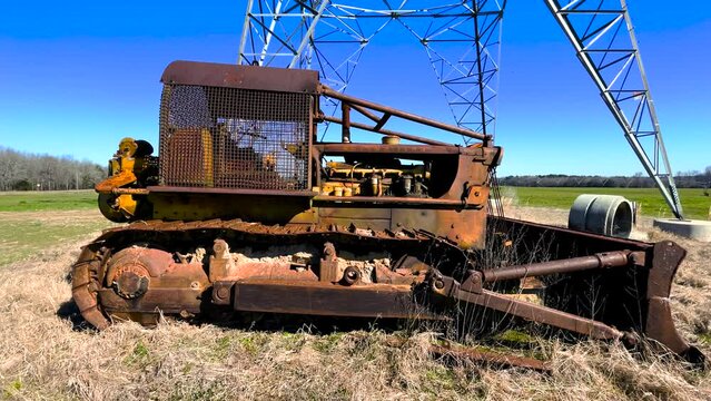 Side distant pan Old antique rusted vintage abandoned tractor on a farm inoperable