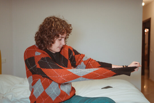Girl taking off sweater in bedroom 