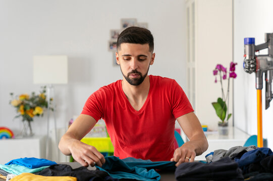 adult male folding clothes carefully on a table