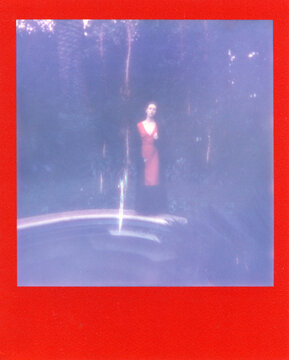 A young woman in red dress near a swimming pool