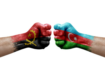 Two hands punch to each others on white background. Country flags painted fists, conflict crisis concept between angola and azerbaijan