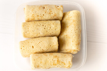 frozen pancakes in a container on a white table