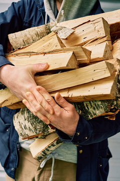 A man holding logs in his hands