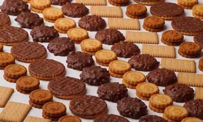 Rows of biscuits glazed with chocolate, round with filling and rectangular crackers arranged in a beautiful pattern
