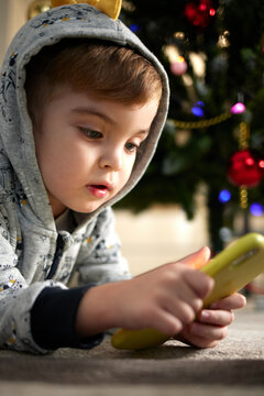 A Child Plays Games On A Smartphone 