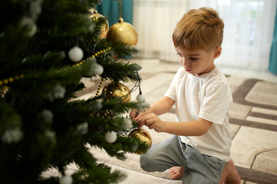 Boy decorates christmas tree 
