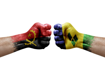 Two hands punch to each others on white background. Country flags painted fists, conflict crisis concept between angola and saint vincent and the grenadines