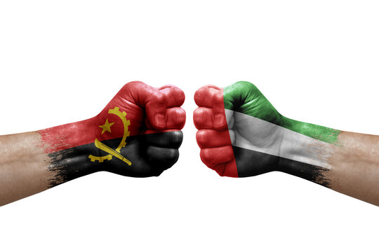 Two hands punch to each others on white background. Country flags painted fists, conflict crisis concept between angola and united arab emirates