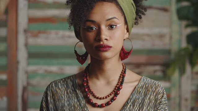 Ethno beauty. Young confident gorgeous stylish african american woman with traditional accessories turning to camera