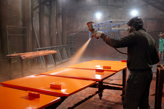 Painting a metal part in production. 