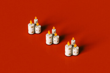 Cartoon Christmas candles on red with large copy space.