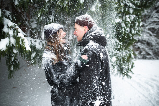 Young couple having fun during snowfall 