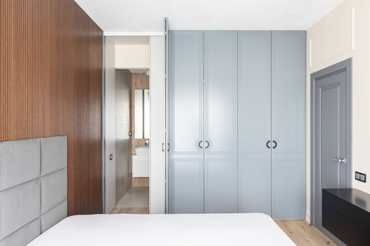 Wardrobe with open door and the entrance of the toilet 