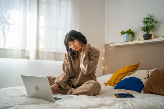Girl On The Bed With Laptop Having Pain In the Neck.