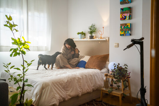 Dog And Asian Girl Playing On The Bed.