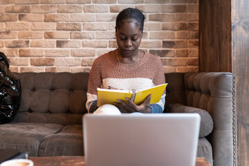 Woman taking notes during online studies