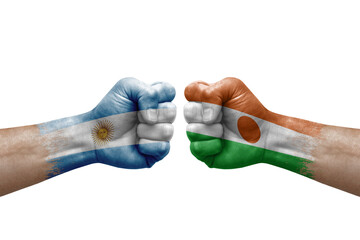 Two hands punch to each others on white background. Country flags painted fists, conflict crisis concept between argentina and niger