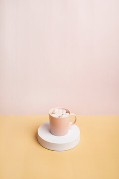 Hot chocolate with marshmallow on pink background