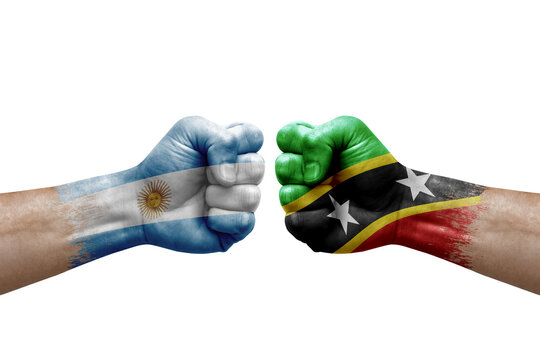 Two hands punch to each others on white background. Country flags painted fists, conflict crisis concept between argentina and saint kitts and nevis